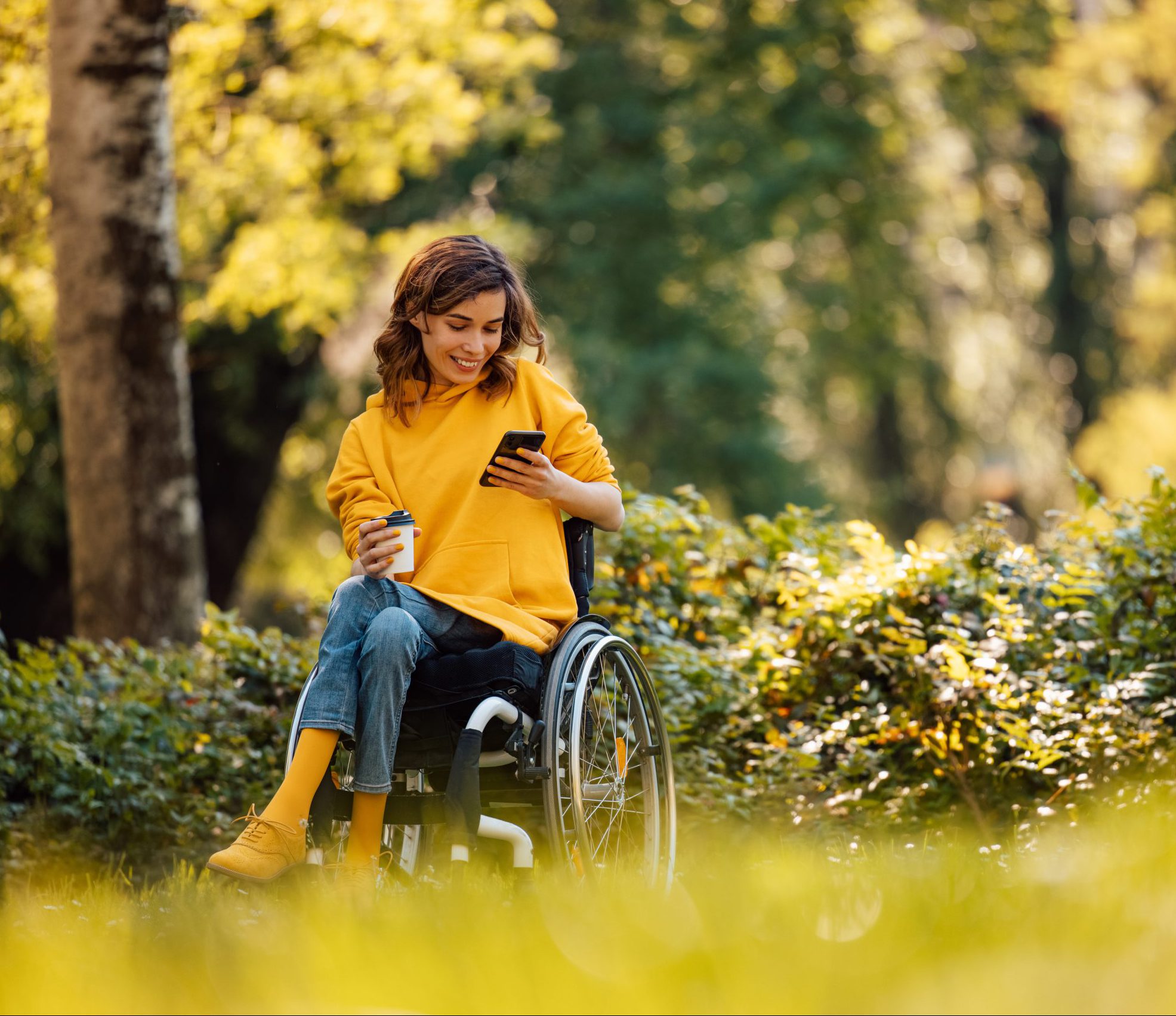 Adult woman in wheelchair going through the park
